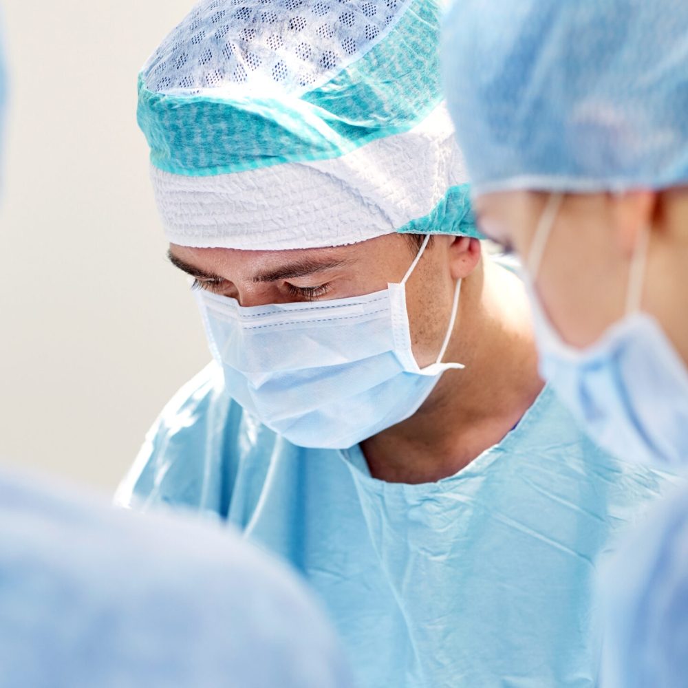 surgery, medicine and people concept - group of surgeons at operation in operating room at hospital