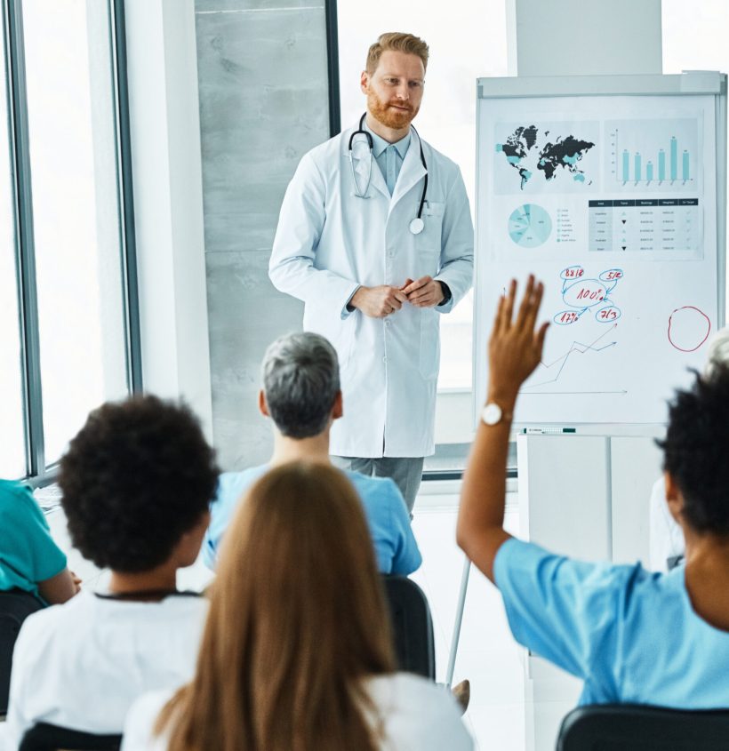 Portrait of a young doctor teaching on a seminar in a board room or during an educational class at convention center